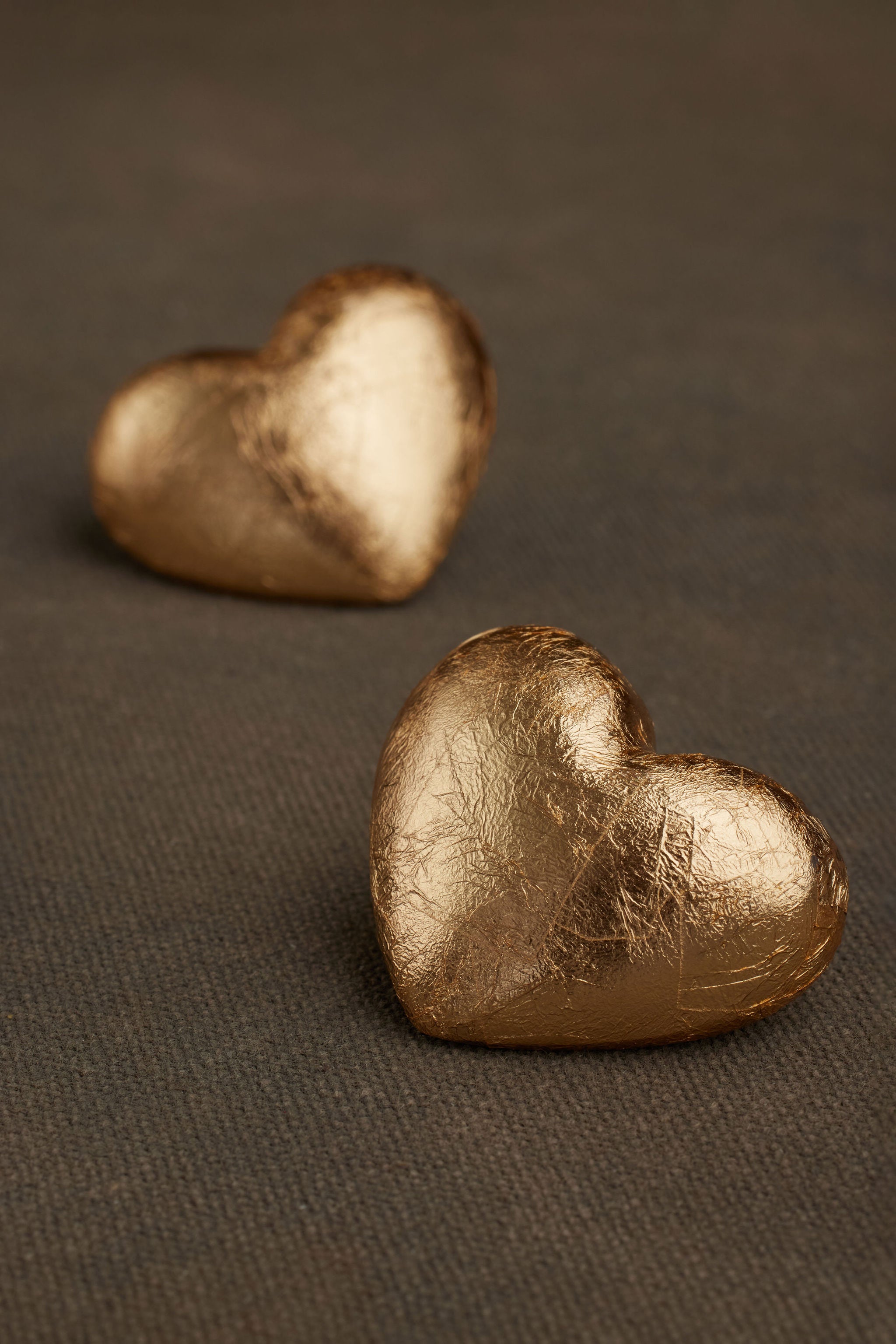 Close-up of AKER gold foil heart shape earrings