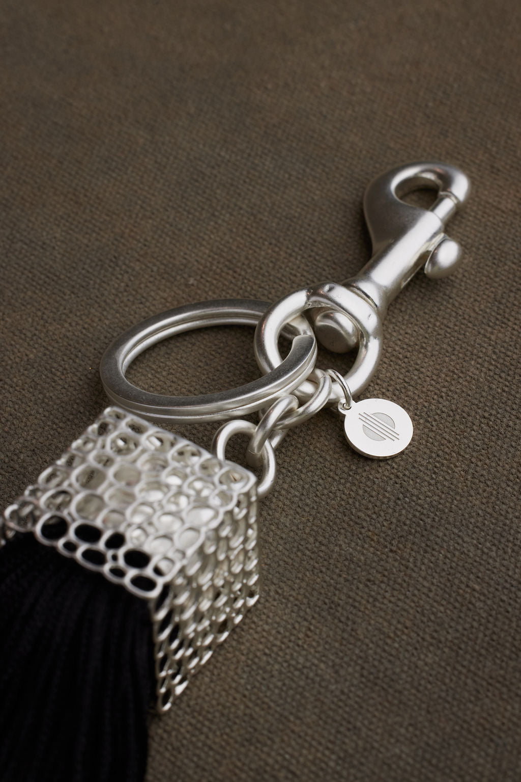 Keychain with tassel and metal clasp on a brown background