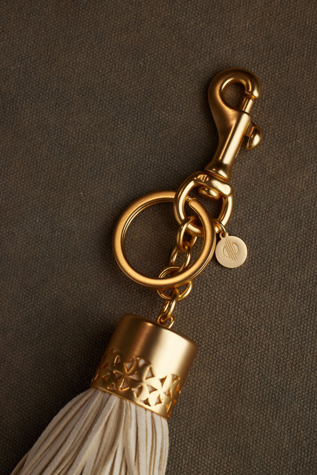 Gold keychain with tassel on a brown background