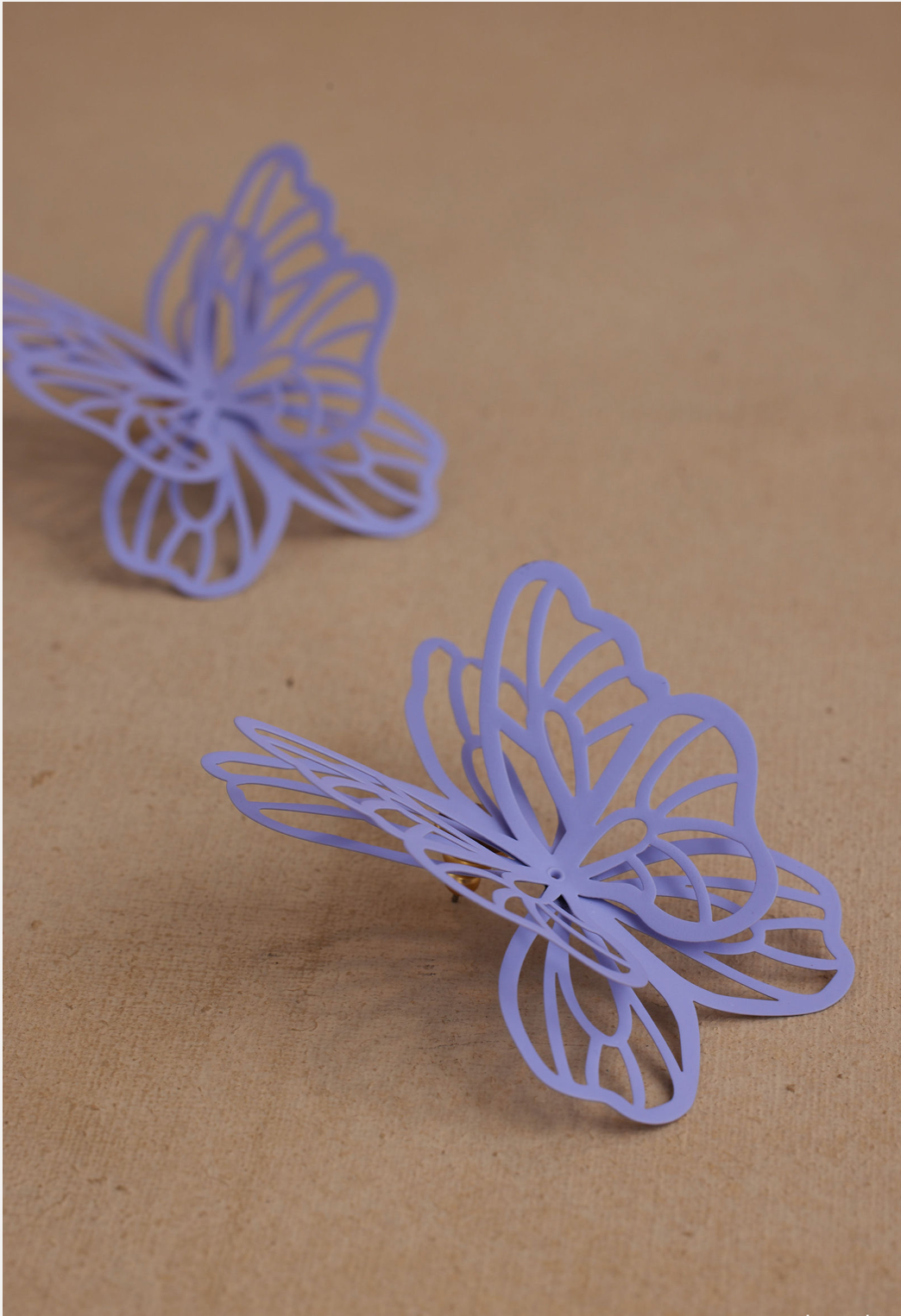 Two purple butterfly-shaped objects on a brown background