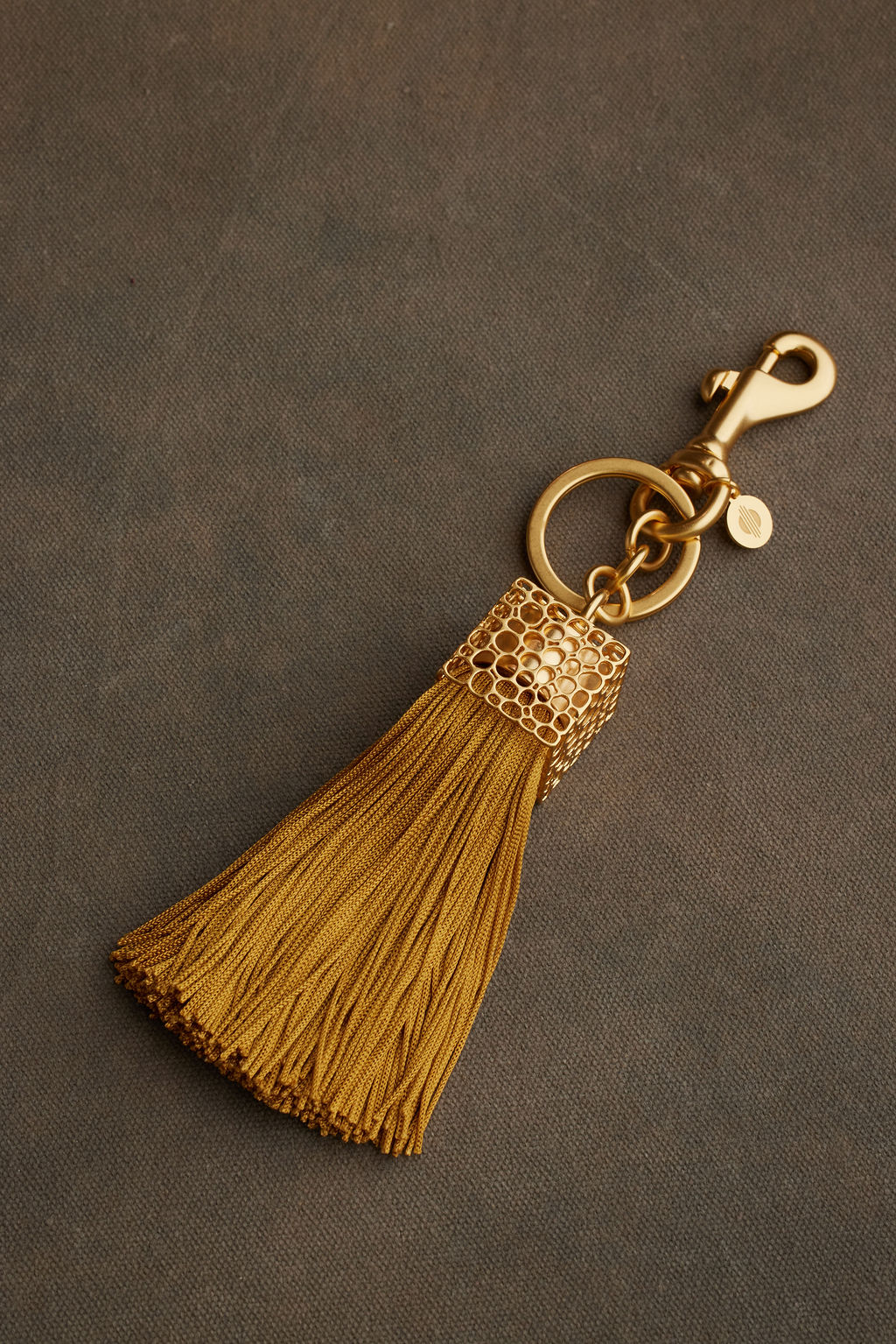 Gold tassel keychain on a brown background