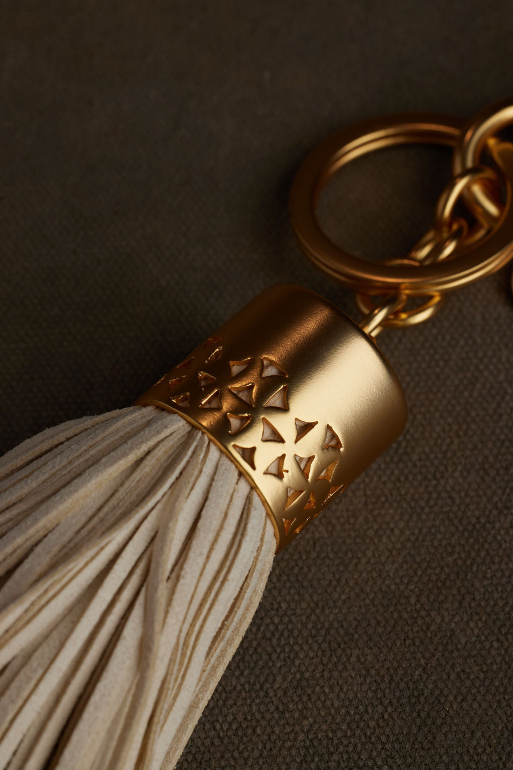 Gold keychain with tassel on a dark background
